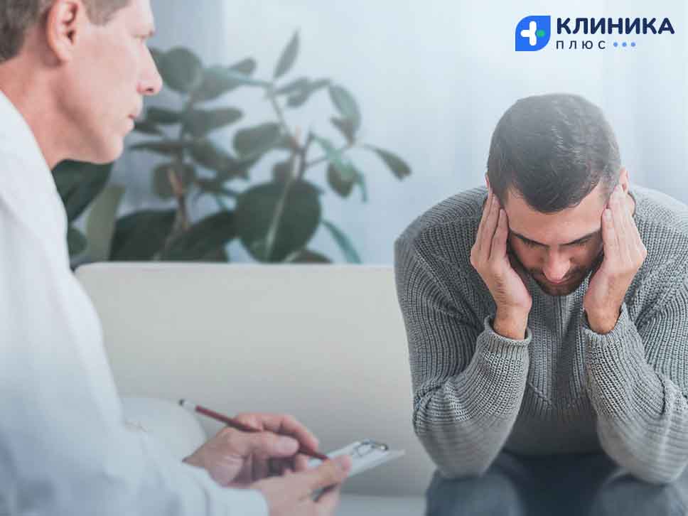 Мужчина сидит у психотерапевта, положив руки на голову